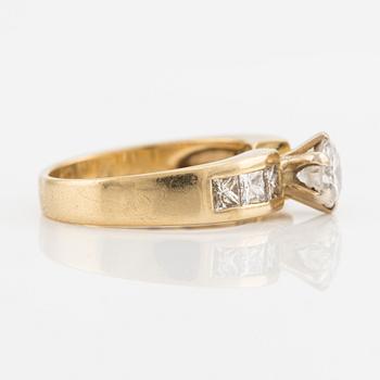 Ring, gold with brilliant-cut diamond and princess-cut on the sides.