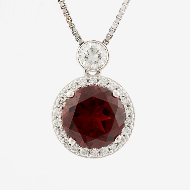 Pendant with a chain in 18K gold set with a faceted garnet and round brilliant-cut diamonds.