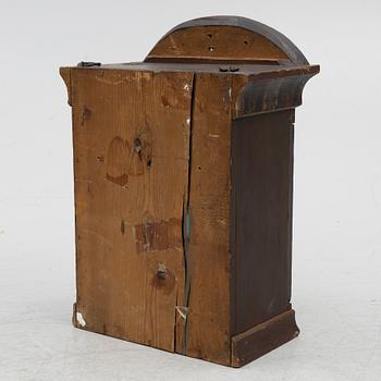 A hanging cabinet, dated 1870.