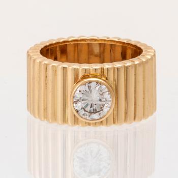 An 18K gold solitaire ring with a round brilliant-cut diamond.