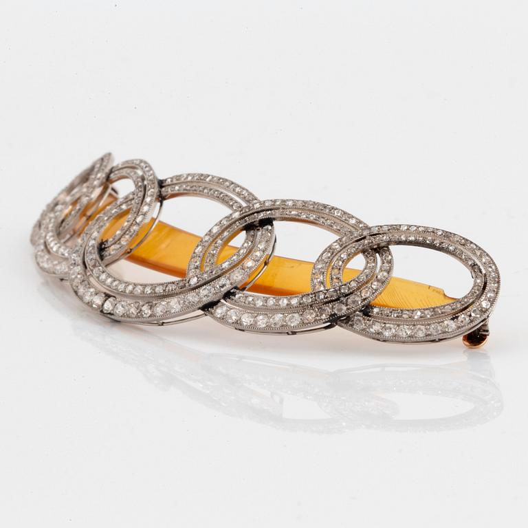 An Art Deco barrette/hairclip signed Cartier in platinum set with old- and rose-cut diamonds.