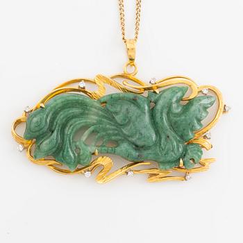 Pendant in gold with a carved green stone, adorned with brilliant-cut diamonds.