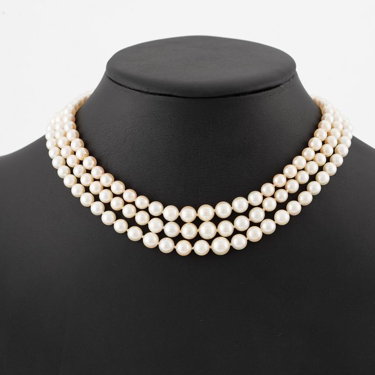 Pärlcollier, treradigt, med doserade odlade pärlor, guld med gammalslipade diamanter och syntetisk rubin.