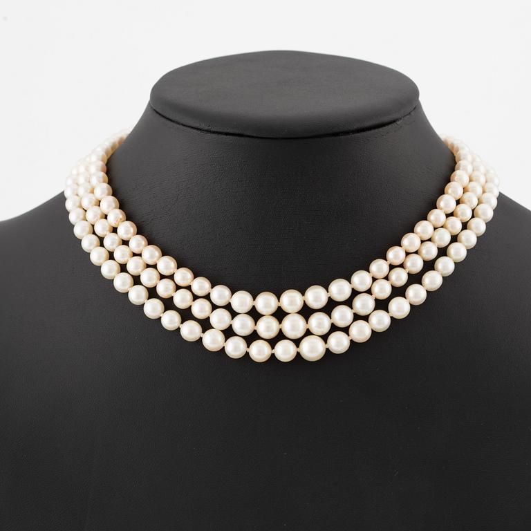 Pearl necklace, three strands, with graduated cultured pearls, gold set with old-cut diamonds and synthetic ruby.