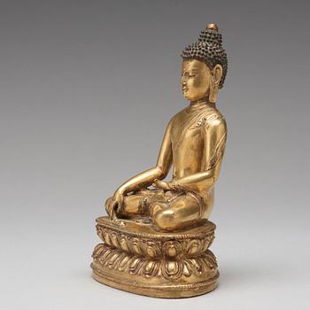 A gilt copper alloy figure of Akshobhya, Tibet, 16th Century.