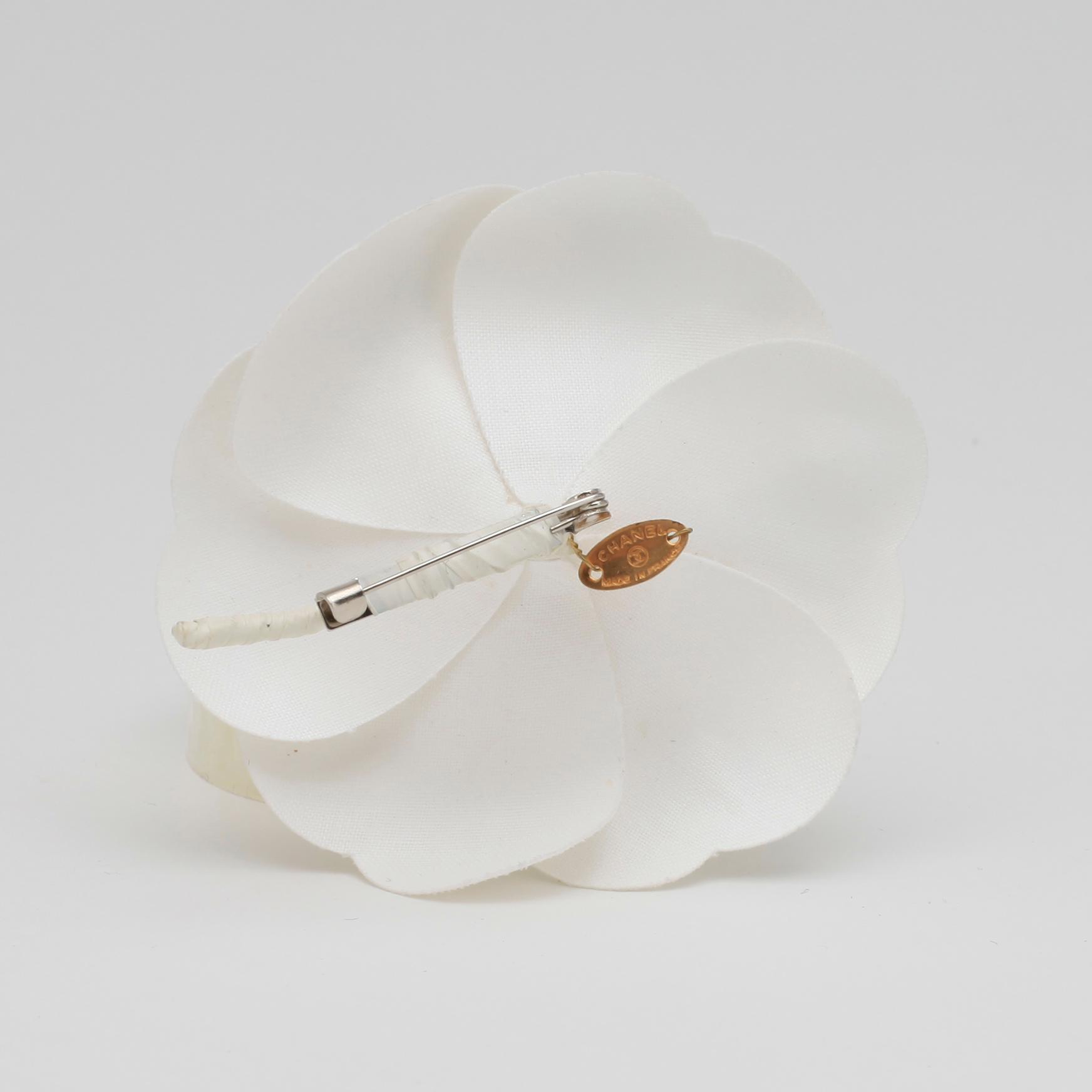 CHANEL, a white brooch.