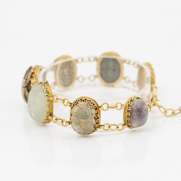 Bracelet in 14K gold with various minerals and scarab-shaped charms.