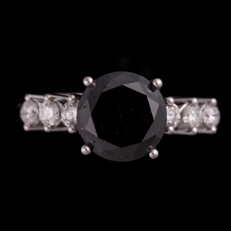 RING, 18K vitguld, svart färgad diamant, 3,09 ct, sidodiamanter tot. 0,32 ct. Vikt 5,6 g. Intyg 336.