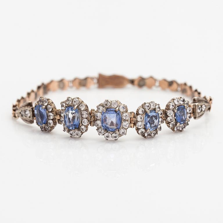 A 4-8K gold bracelet with light blue and white sapphires.