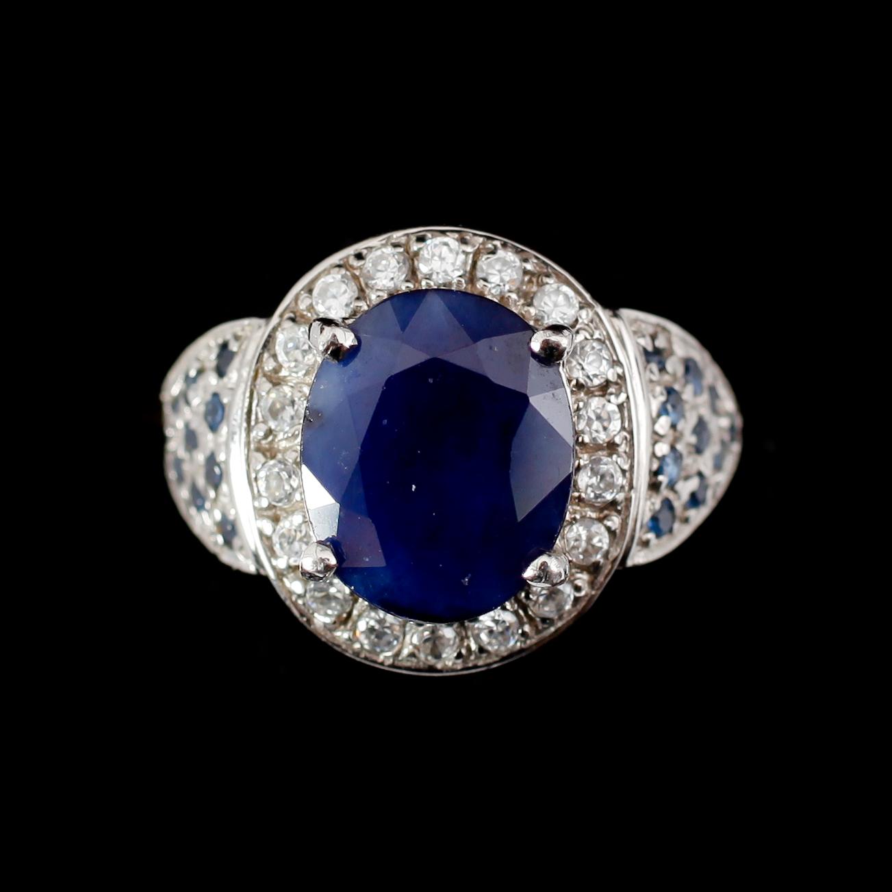 RING, silver, blå safir ca 3,0 ct, mindre safirer samt vita stenar.