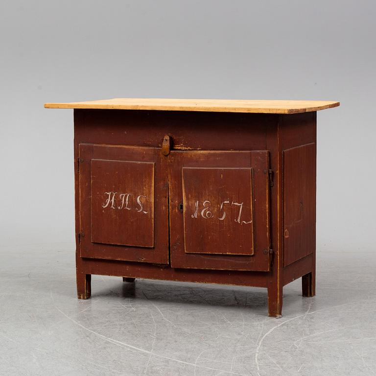 A painted table with cabinet, dated 1857.