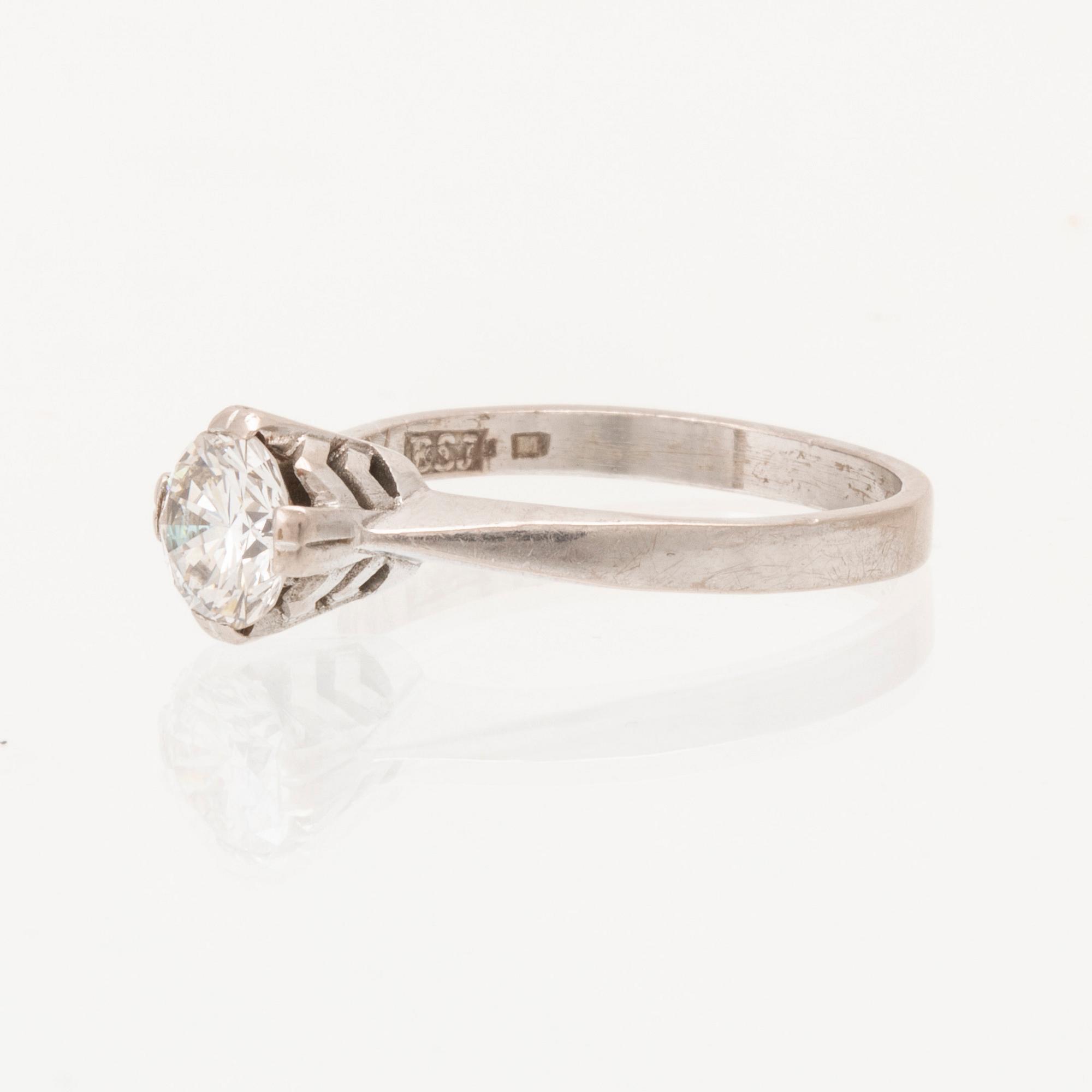 An 18K white gold solitaire ring set with a round brilliant cut diamond.