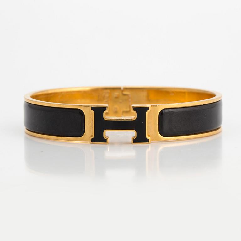 Black enamel and golden bracelet "Clic H" by Hermès.