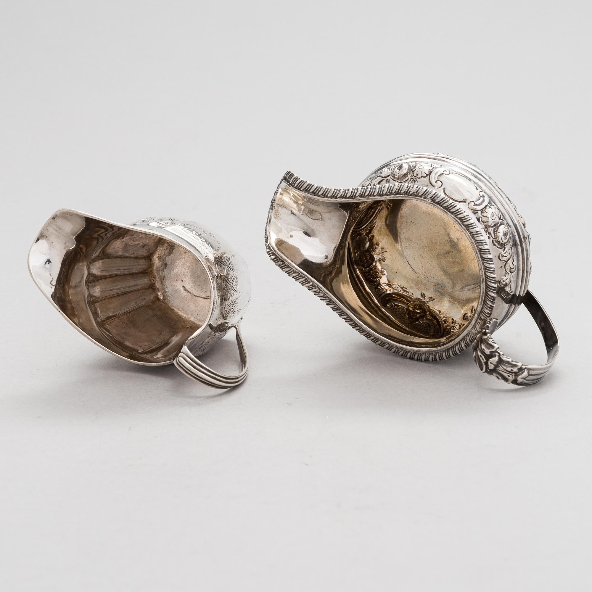 Two sterling silver milk jugs, London 1794 och 1828.