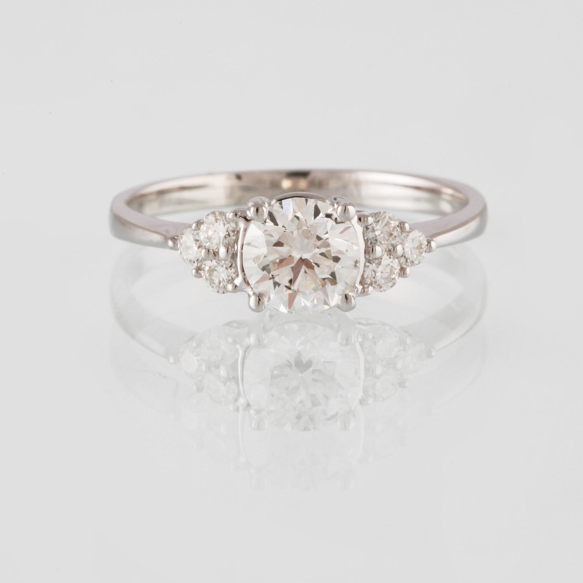 RING, 18K vitguld med en briljantslipad diamant 0.71 ct samt små briljantslipade diamanter 0.18 ct. Vikt 2,3 gram.