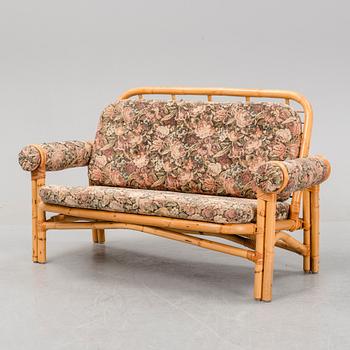 A set of two garden sofas, an armchair and a glass table, later part of the 20th Century.