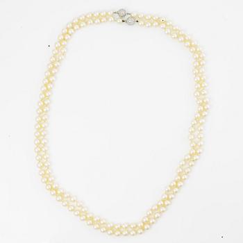 Two necklaces of cultured pearls clasp set with round brilliant-cut diamonds, 18K gold.