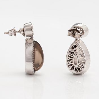 A pair of 18K white gold earrings with diamonds ca. 0.64 ct in total, smoky quartzes and topazes. Tirisi, The Netherland.