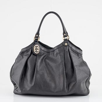 Gucci, a black leather bag.