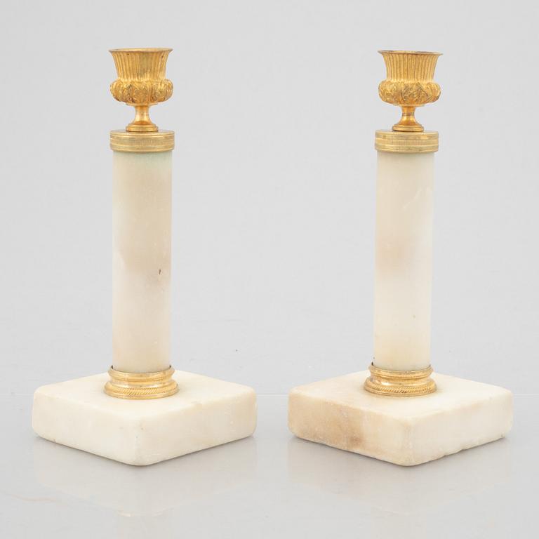 A pair of marble and gilt-bronze Louis XVI-style candelsticks, circa 1900.