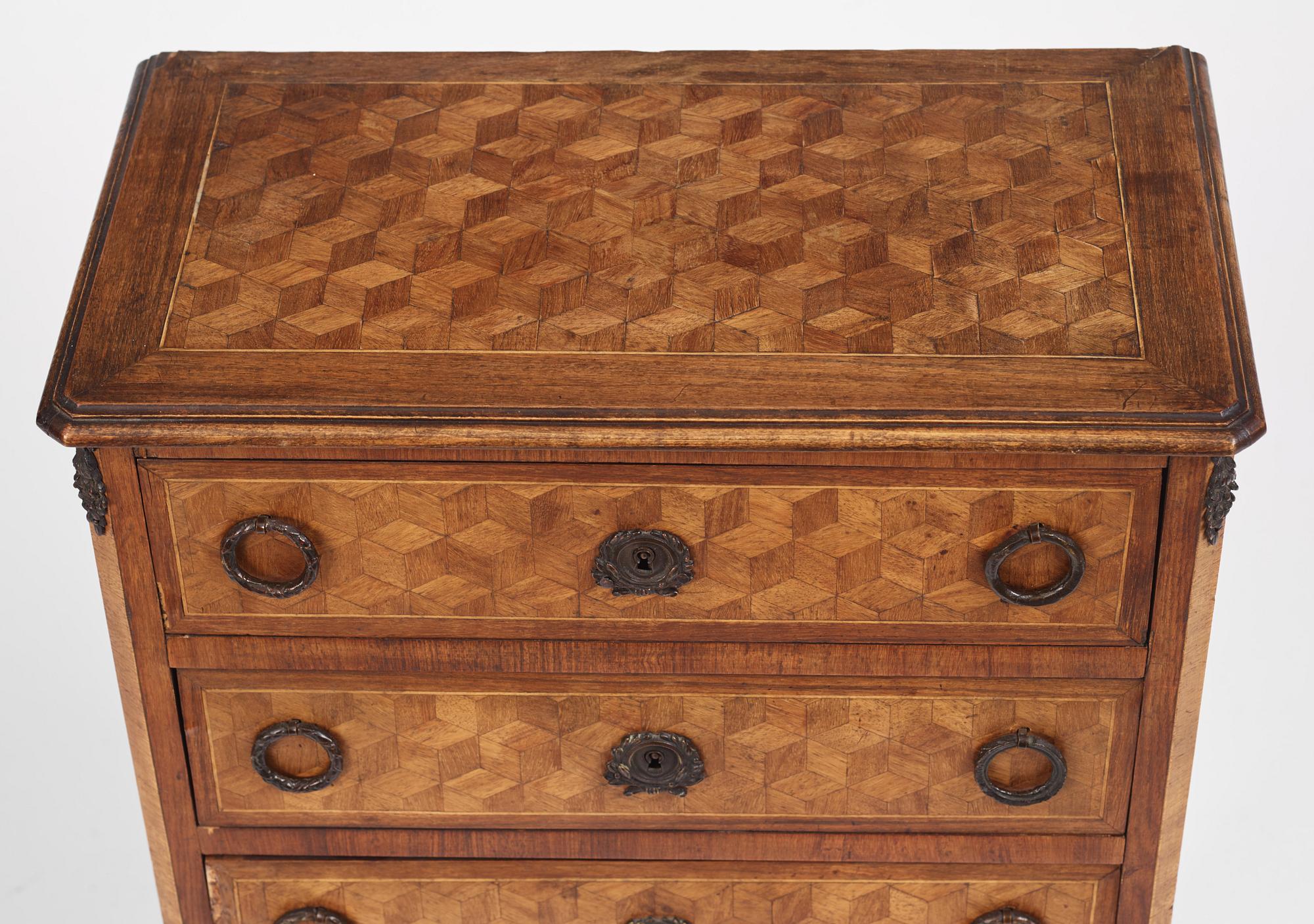 A Louis XVI-style parquetry commode, circa 1900.