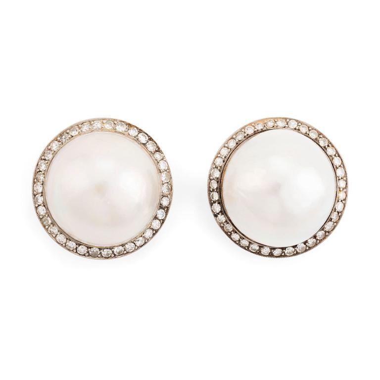 A pair of 18K white gold earrings set with cultured mabe pearls and round brilliant-cut diamonds.