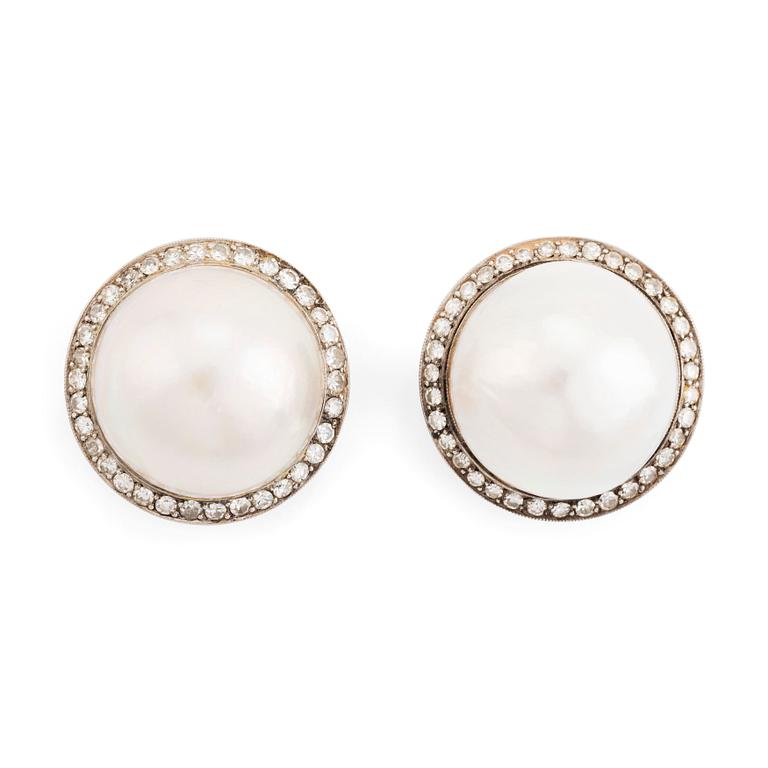 A pair of 18K white gold earrings set with cultured mabe pearls and round brilliant-cut diamonds.