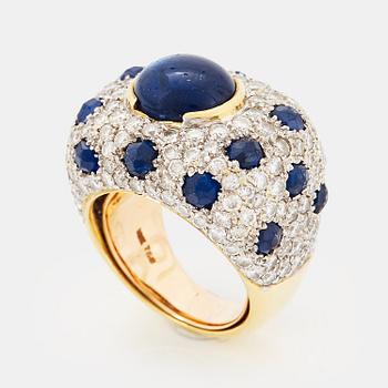 1029. An 18K gold ring set with a cabochon-cut sapphire and round brilliant-cut diamonds and faceted sapphires.