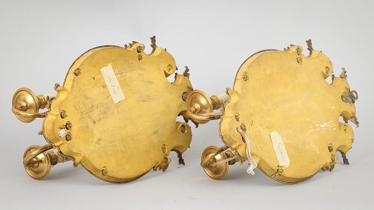 A pair of late Baroque-style circa 1900 gilt bronze two-light girandole mirrors.