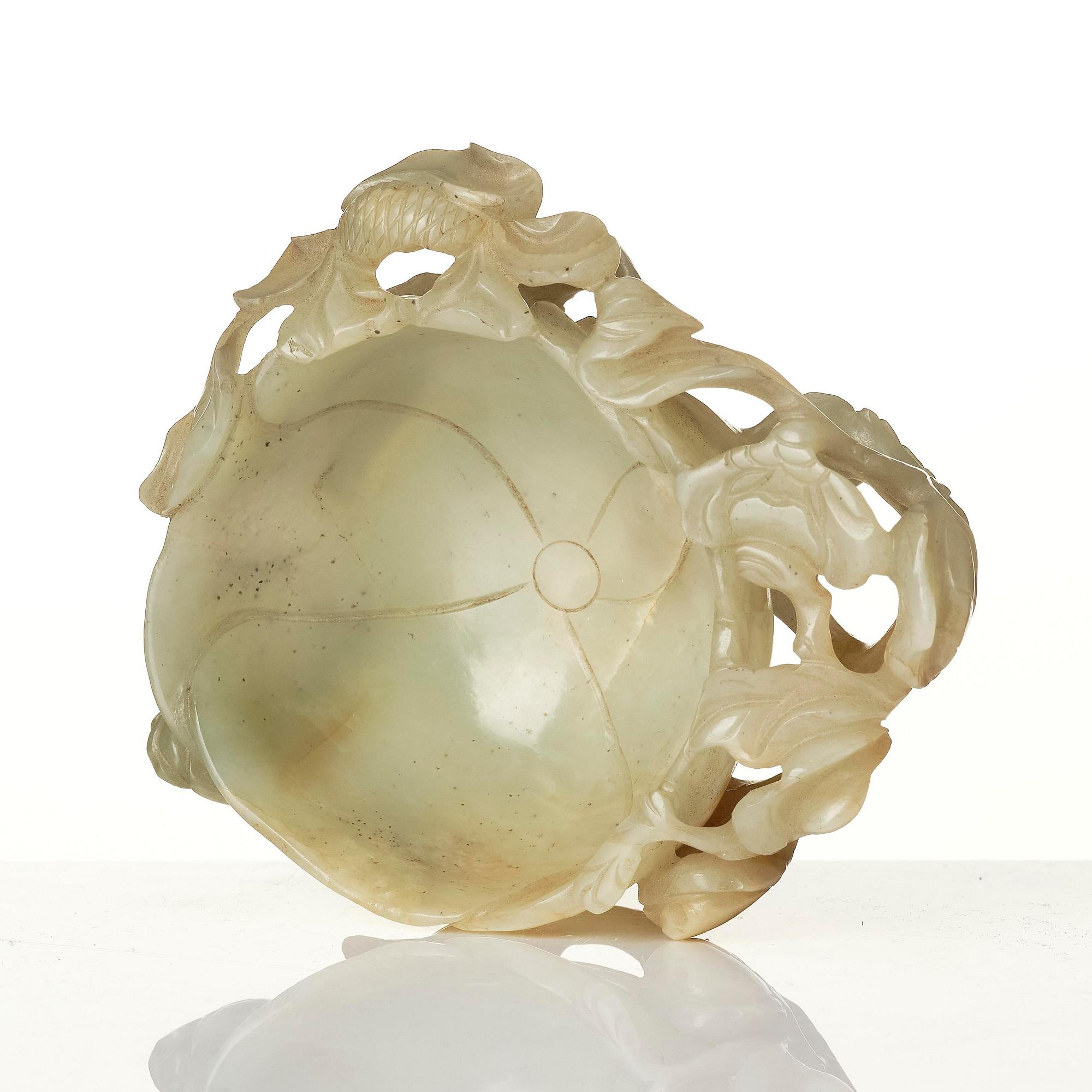 A carved Chinese nephrite cup in the shape of a lotus leaf, late Ming dynasty.