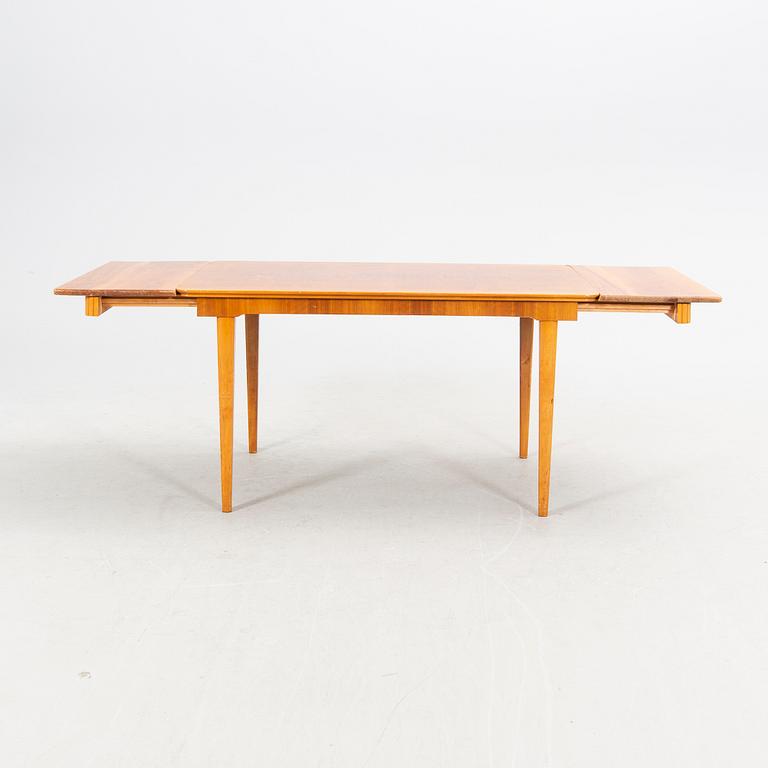 A 1940s mahogany and walnut dining table.