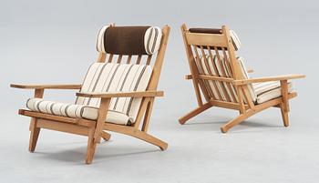A pair of Hans J Wegner oak and fabric easy chairs, Getama, Gedsted, Denmark 1950's-60's.