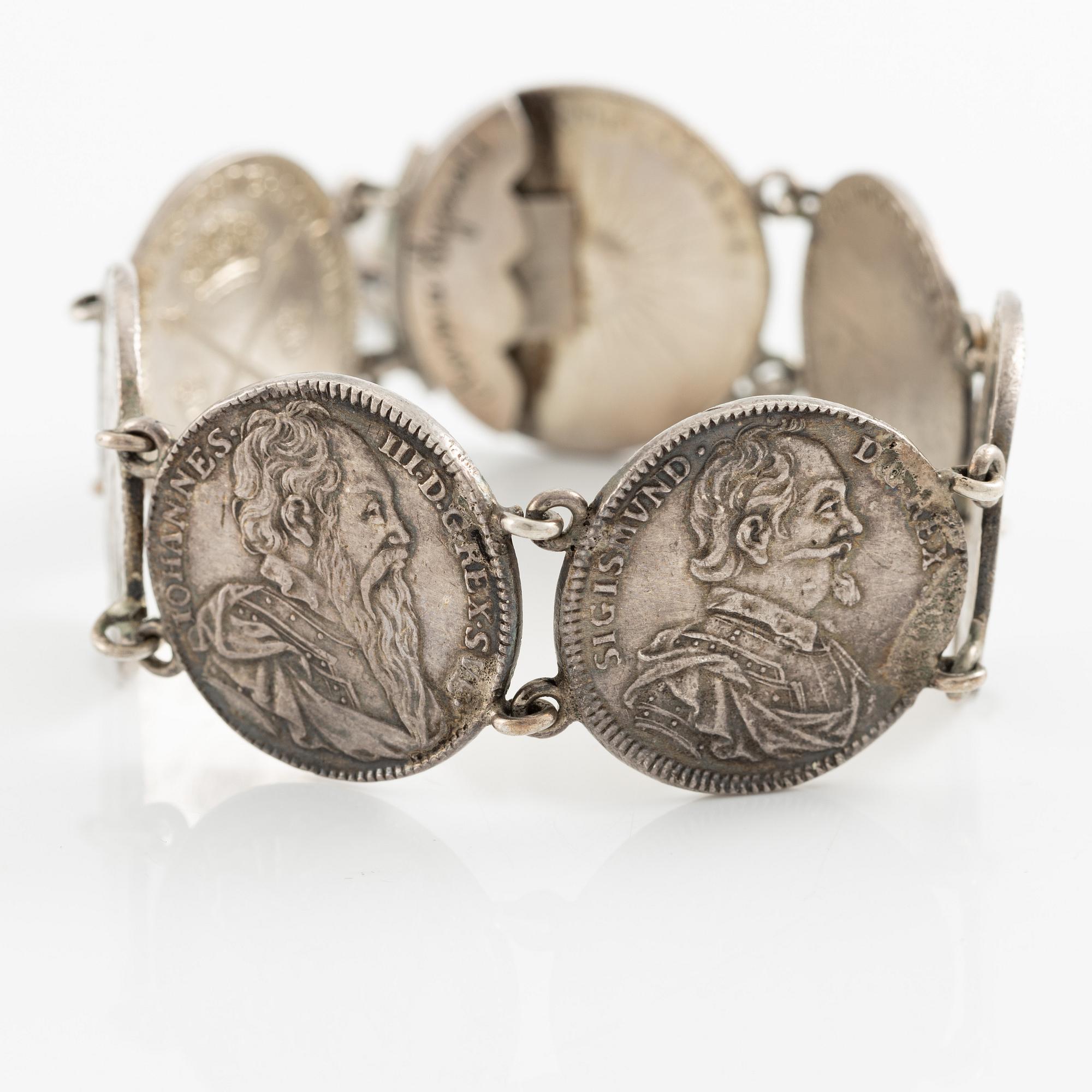 Two bracelets, a brooch, and a pendant with coins.