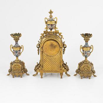 A set of two Louis XVI-style candle sticks and a mantle clock, late 19th century.