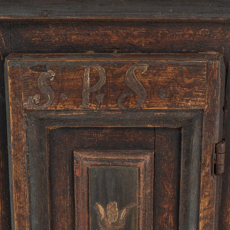 A painted corner cabinet, dated 1800.