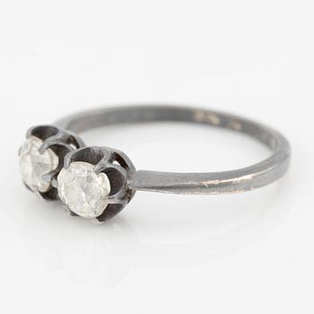 Ring in dark metal, possibly 14K gold, with two old-cut diamonds.