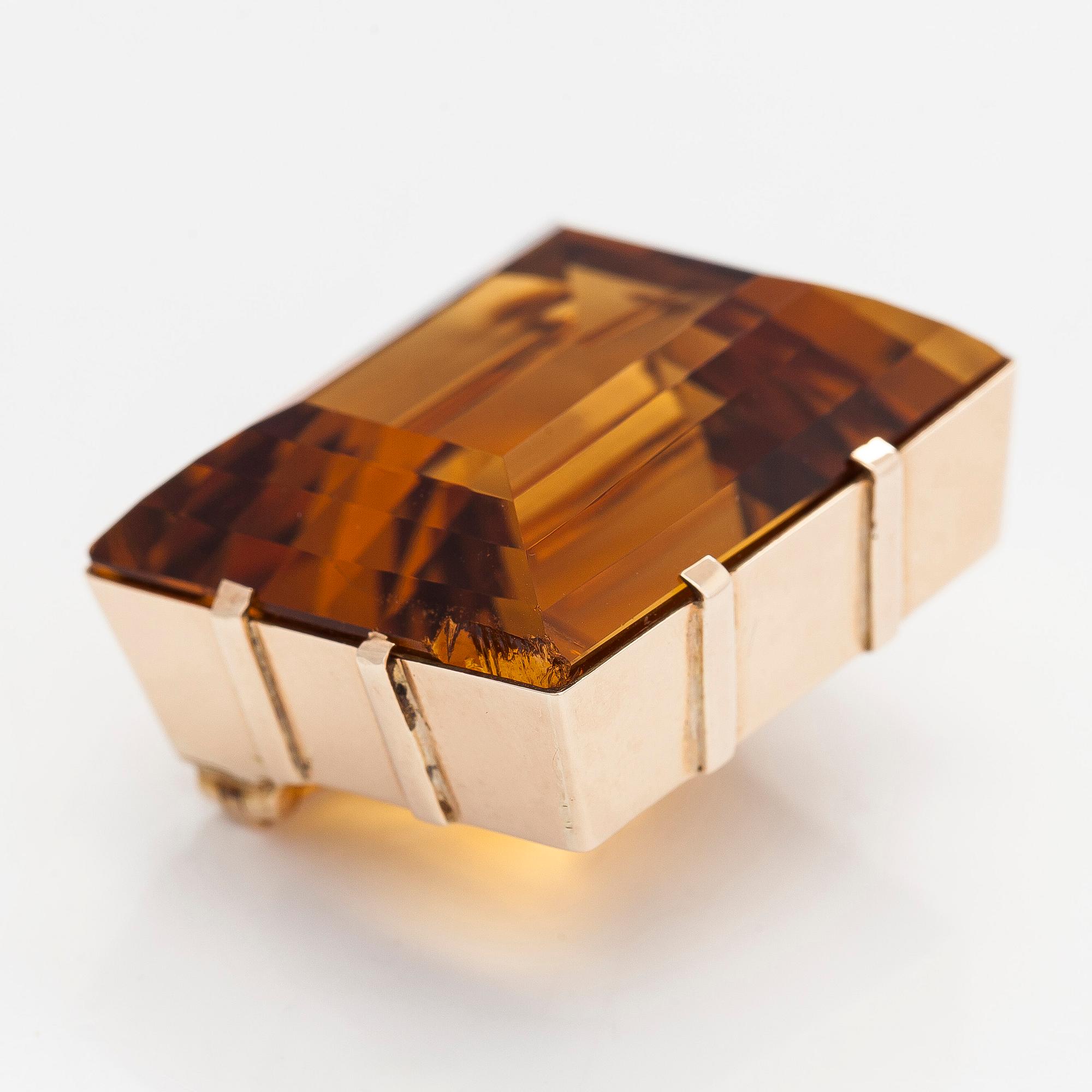 A ca 13K gold brooch, set with a step-cut Madeira citrine approximately 119.0 ct.