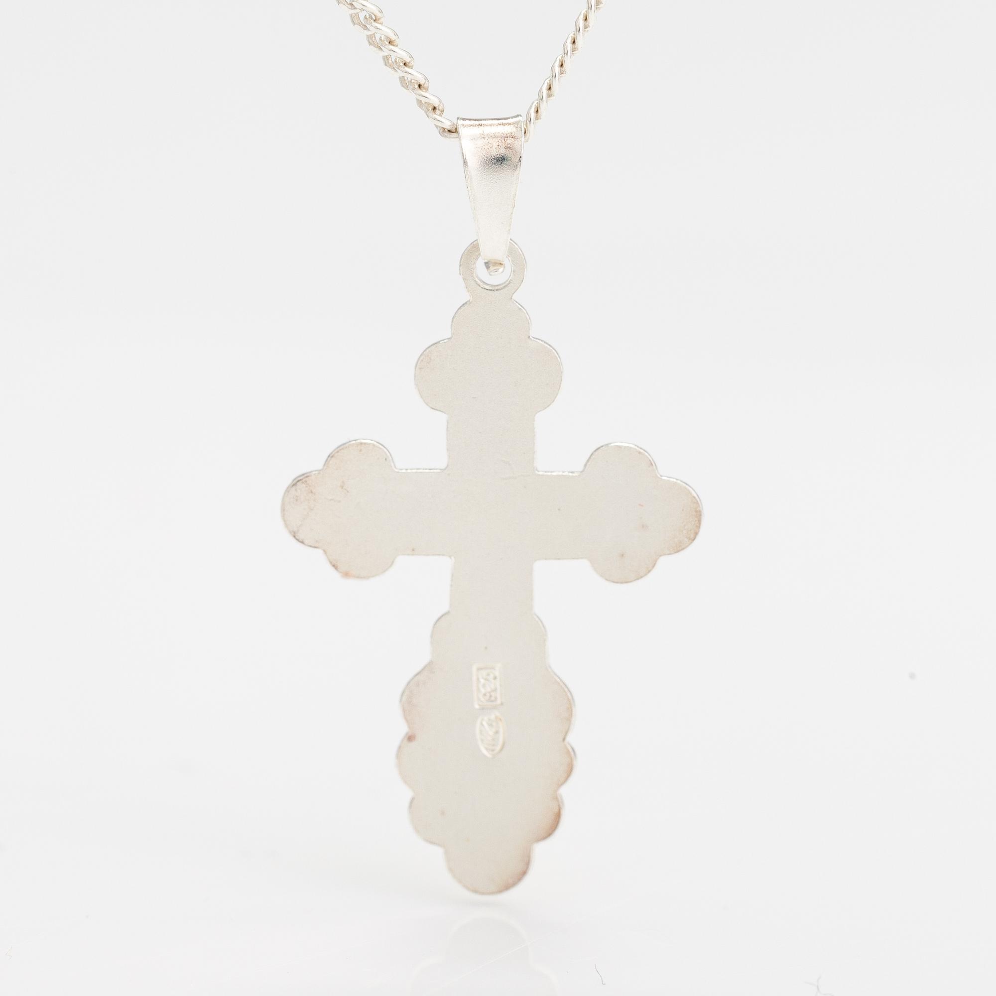 A stelring silver necklace with a cross.