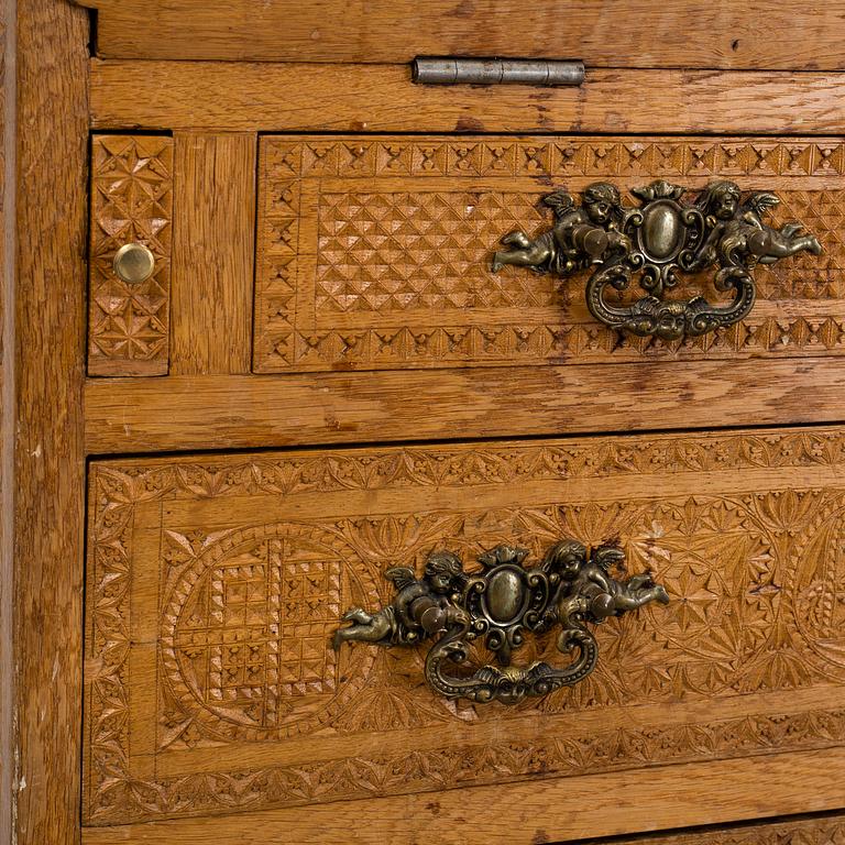 A carved oak secretaire, 19th Century.