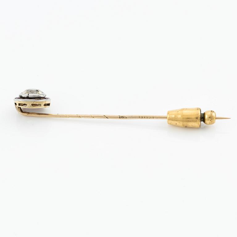 An 18K gold brooch pin with an old-cut diamond.