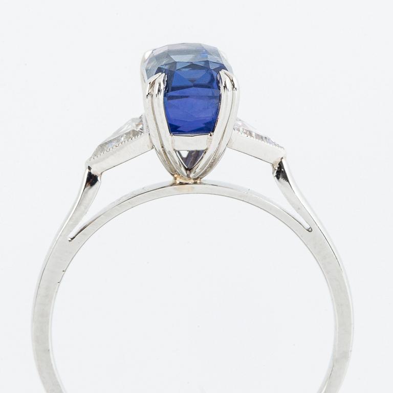 RING, platina, med fasettslipad violettblå safir och triangelslipade diamanter, medföljande certifikat.