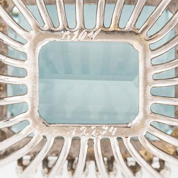An 18K white gold Engelbert pendant set with a aquamarine and round brilliant-cut diamonds.