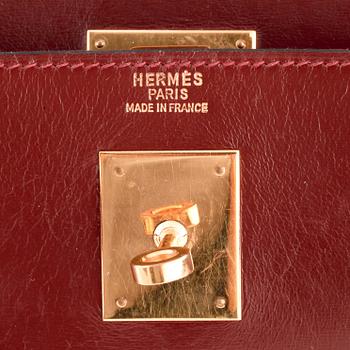 HERMÈS, a burgundy red leather handbag, "Kelly 32".