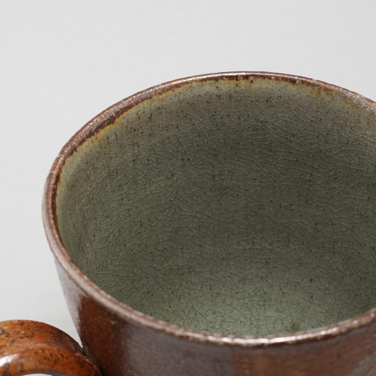 A tea pot and three tea cups in saltglazed stoneware by Christer Sjöblom, signed tea pot.