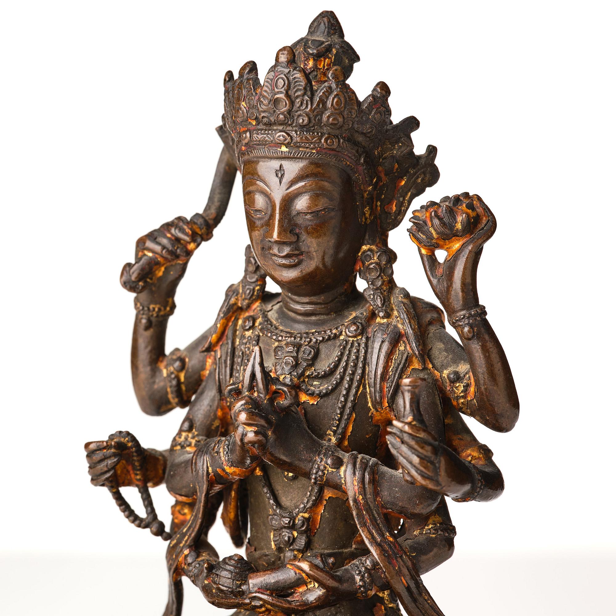 A cold gilt copper alloy figure of eight armed Boddhisattva Avalokiteshvara, late Ming dynasty.