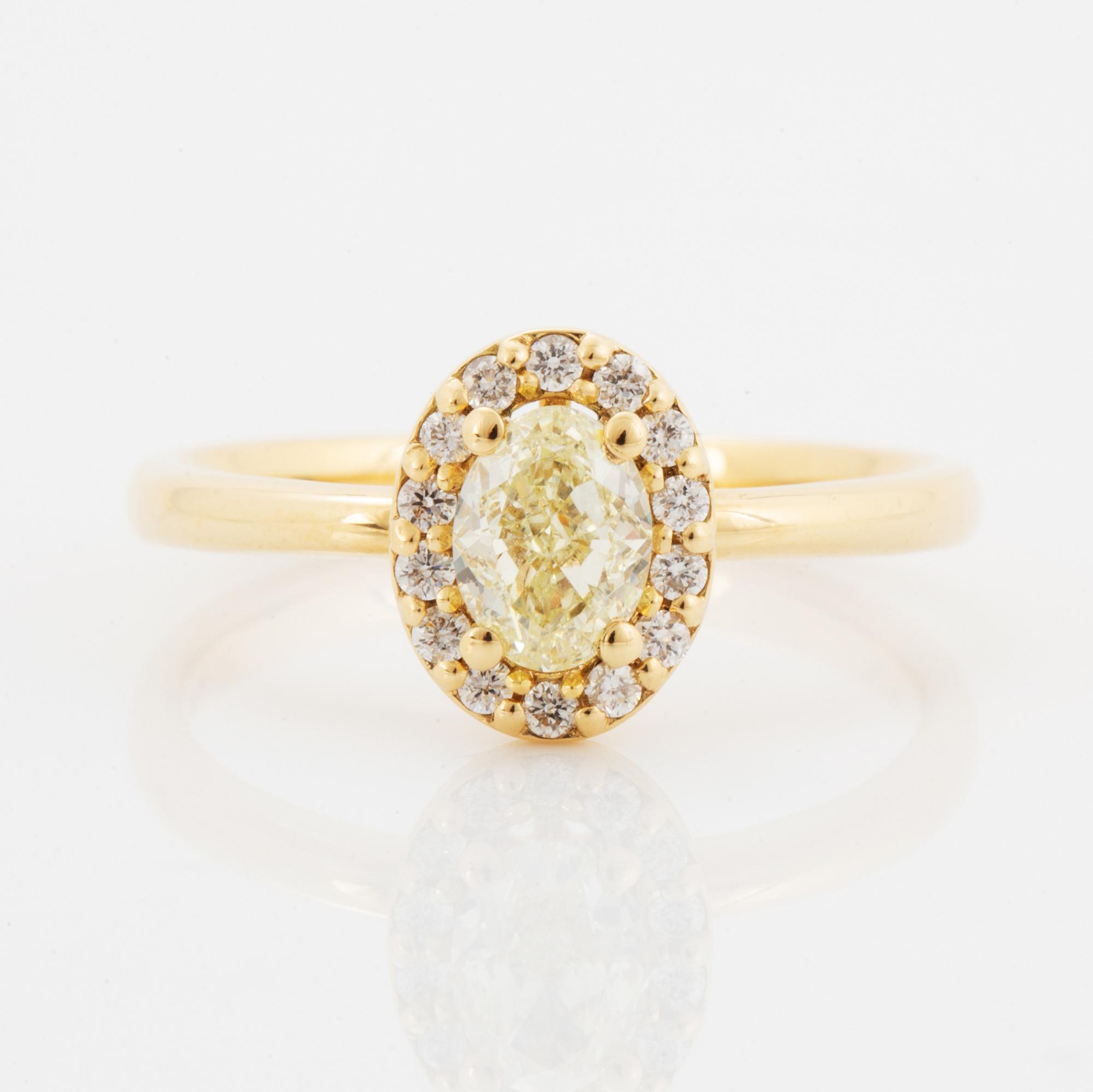 Oval light yellow diamond and brilliant-cut diamond ring.
