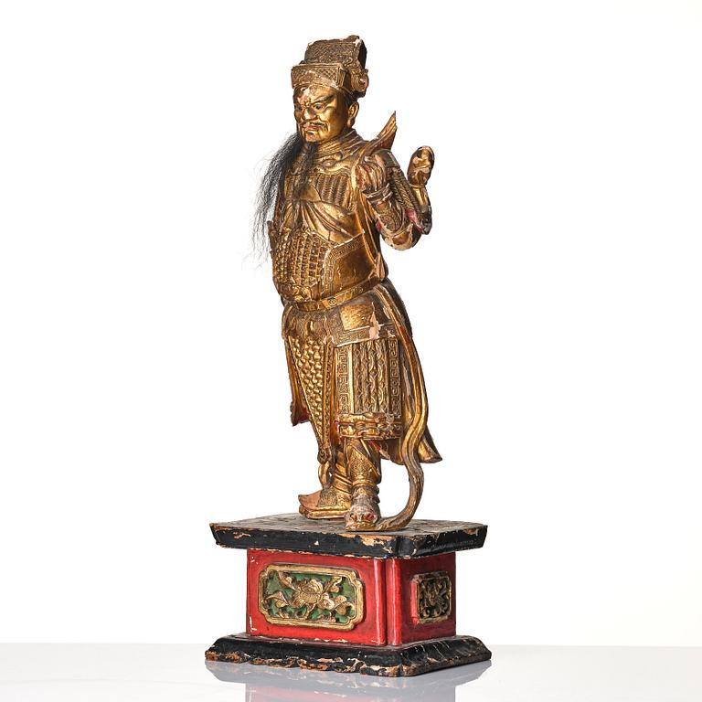 A gilt and lacquered standing figure of a guardsman, Qing dynasty.