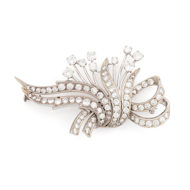 An 18K white gold brooch set with round brilliant-cut diamonds.