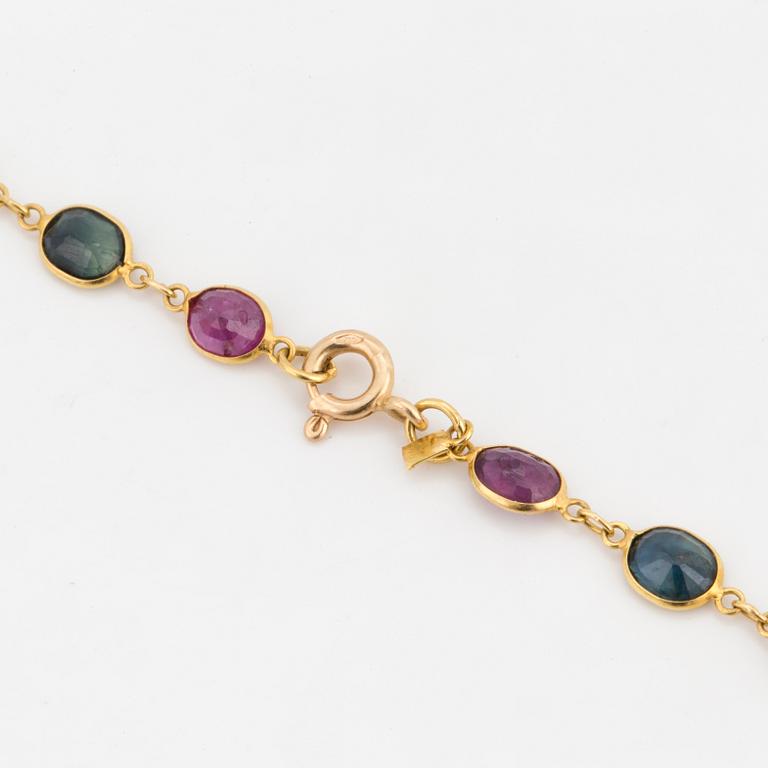 A necklace set with oval, mixed-cut, multi-coloured gemstones.