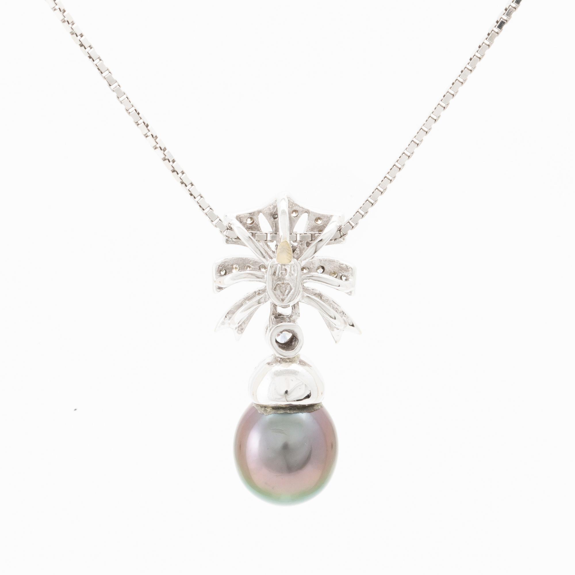 An 18K white gold necklace set with a drop-shaped cultured pearl and round brilliant-cut diamonds.